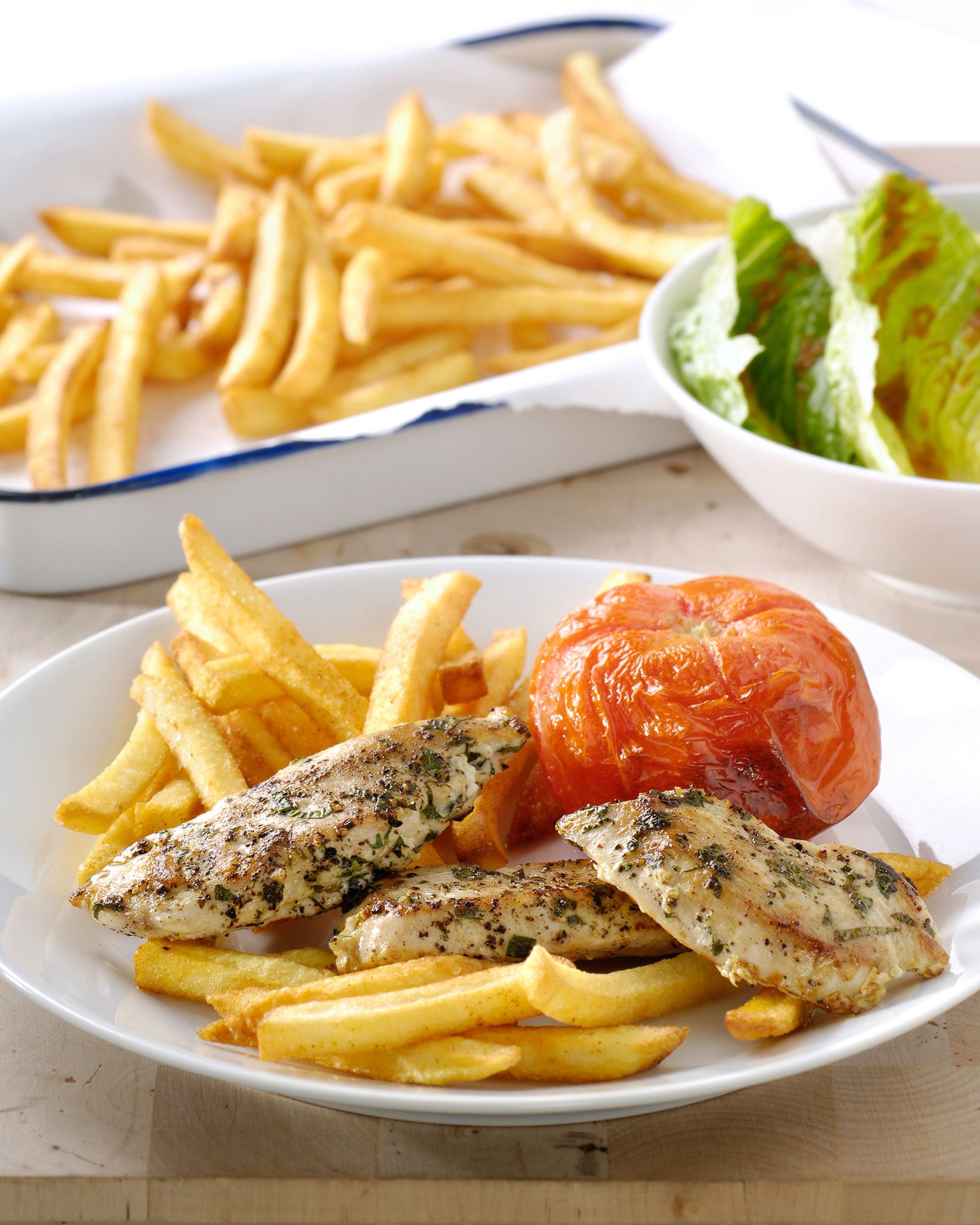 recipe image Gebakken kipfilet met kruidige ovenfrites en geroosterde tomaatjes