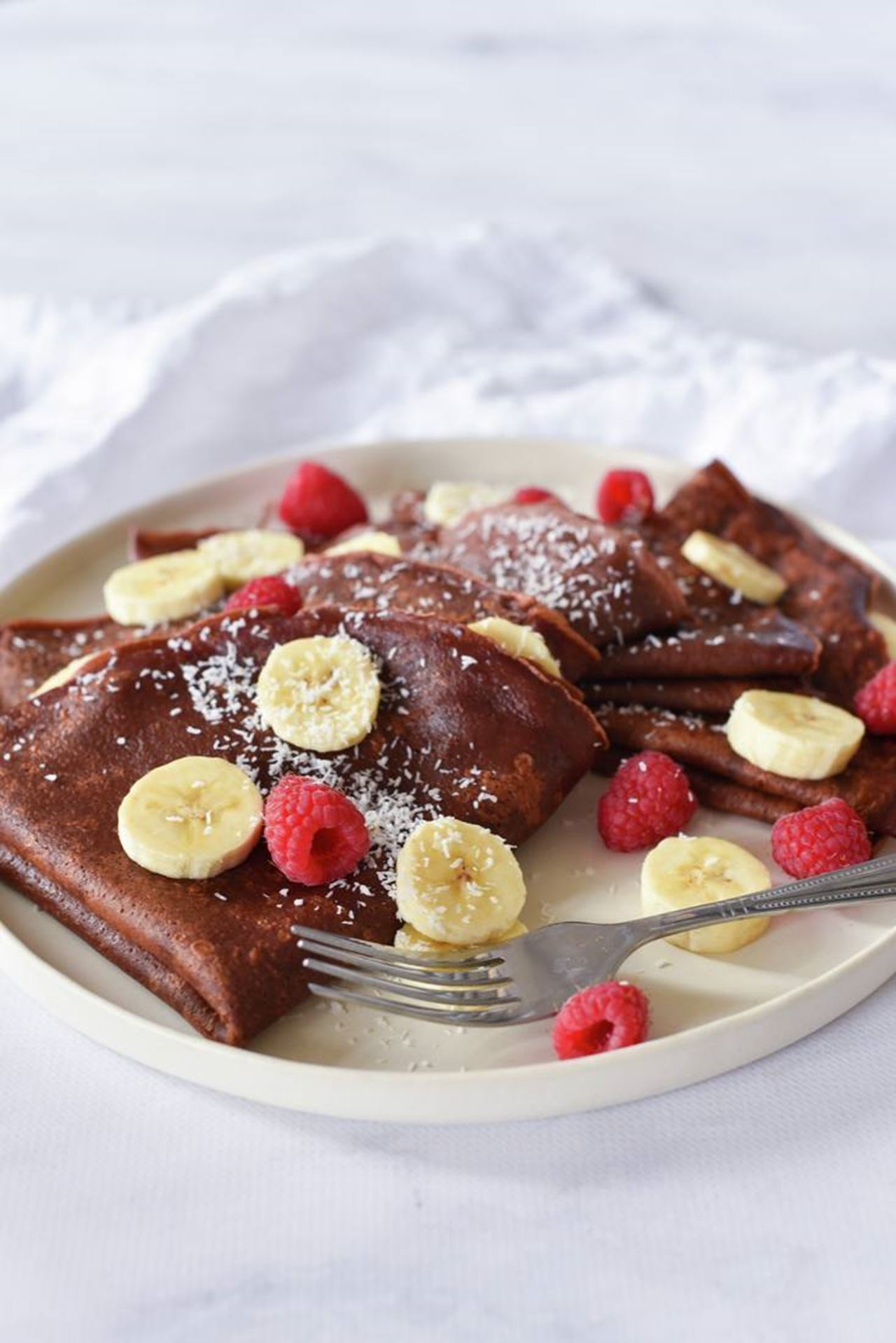 recipe image Beste pannenkoeken recept ooit, chocolade pannenkoeken met banaan en frambozen
